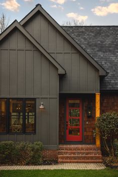 a house with a red door and brick steps leading up to the front entrance area