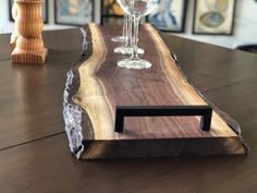 two wine glasses sitting on top of a wooden table next to an empty glass holder