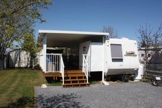 a white mobile home with stairs leading up to the front door and covered porch area