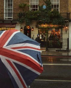 an umbrella with the british flag on it is seen in front of a storefront