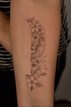 a woman's arm with a lion and flower tattoo on the left side of her leg