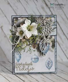 a close up of a christmas card on a wooden table with snowflakes and ornaments