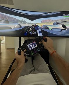 a man sitting in front of a flat screen tv holding a game controller