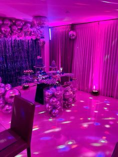 a room filled with purple lights and balloons