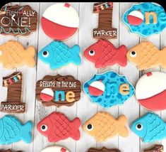 decorated cookies are arranged in the shape of fish and letters that spell out one word