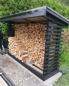 a large pile of wood sitting on top of a wooden bench next to a forest