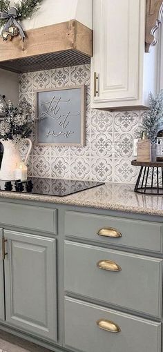 a kitchen with white cabinets and gray counter tops, decorated for the holiday season or christmas