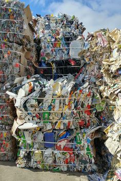 a pile of cans stacked on top of each other in front of a blue sky