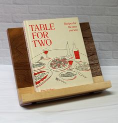 a table for two book on a wooden stand