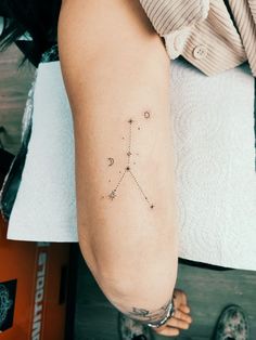 a woman's arm with a small star tattoo on it