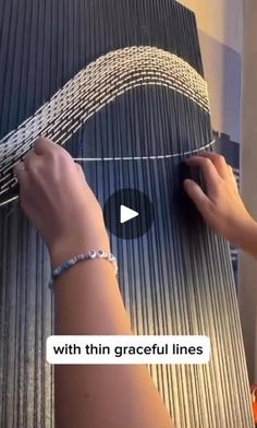 two hands are working on a large piece of art that is being made out of corrugated