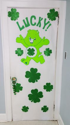 a door decorated with clover leaves and a green teddy bear on it's side