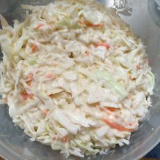 a bowl filled with coleslaw sitting on top of a table