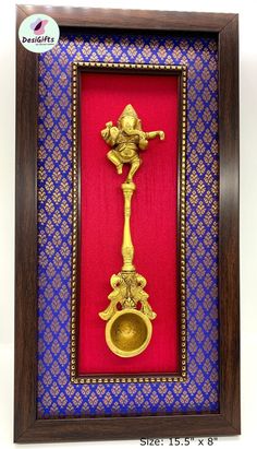 an ornate golden metal candle holder in a wooden frame with red and blue wallpaper