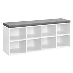 a white shelf with several compartments and a gray cushion on top, against a white background