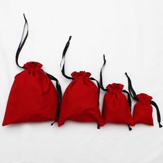 three red bags are lined up on a white surface