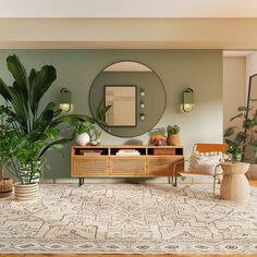 a living room filled with furniture and potted plants in front of a round mirror