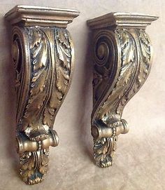 two ornately designed metal wall sconces on display