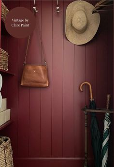 a hat is hanging on the wall next to a purse and umbrella in a closet