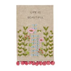 an embroidered book with flowers and words on the cover, that says life is beautiful