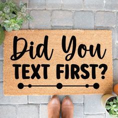 a door mat with the words did you text first? next to potted plants