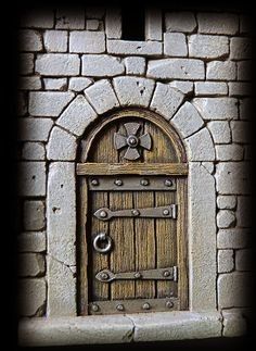 an old door in a stone wall with a star on the front and side window