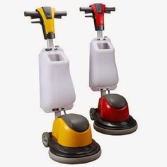 two floor scrubers sitting next to each other on top of a white surface with red and yellow handles