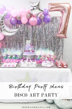 a birthday party table with balloons, cake and other items for the first birthday party