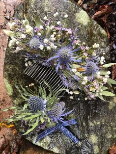 a comb with flowers on it sitting on a rock