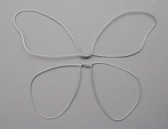 a piece of metal wire with a butterfly on it's back and two leaves attached to the side