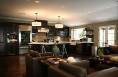 a living room filled with furniture next to a kitchen