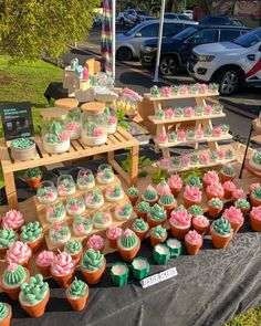 many cupcakes are on display at an outdoor market