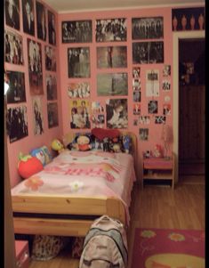 a bedroom with pink walls and pictures on the wall