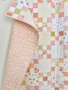 a pink and white quilt with flowers on it