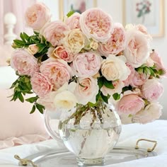 a vase filled with pink and white flowers on top of a bed