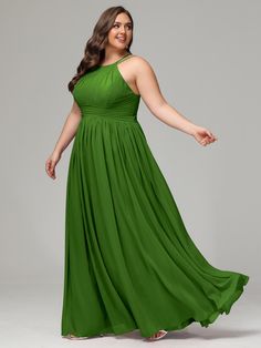 a woman in a long green dress posing for the camera with her arms spread out