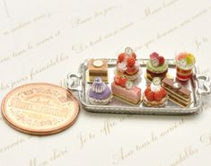 small miniature cakes on a silver tray next to a penny