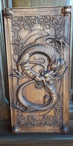 an intricately carved wooden panel with a dragon on it