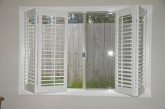 an open window with shutters on the outside