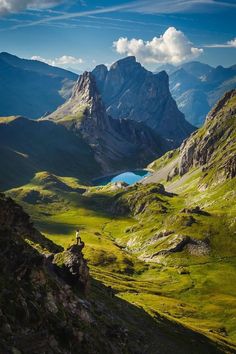 the mountains are covered in green grass and blue water, with a small lake at the bottom