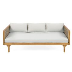 a white couch with four pillows on it's back and two sides, in front of