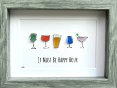 three framed glasses with different drinks in them that says, it must be happy hour