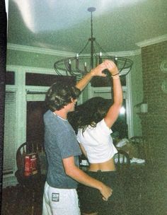 two people are dancing in a room together