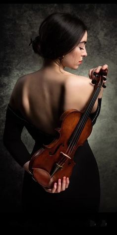 a woman in black dress holding a violin