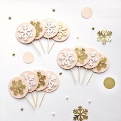 paper snowflake cake toppers and confetti sticks on a white background