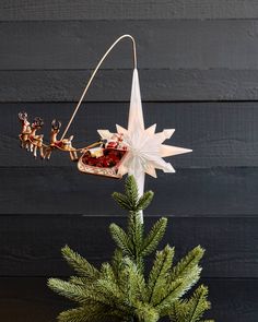 an ornament hanging from the top of a christmas tree with santa's sleigh on it