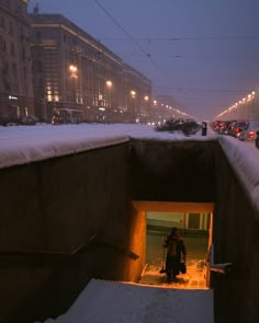 a person walking out of a tunnel in the snow