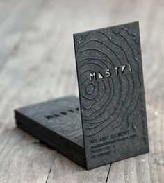 a business card sitting on top of a piece of black paper with the word msty printed on it