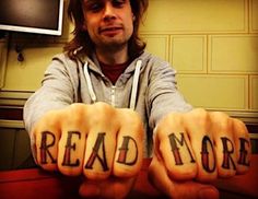 a man sitting at a table with his hands in the shape of words reading read more