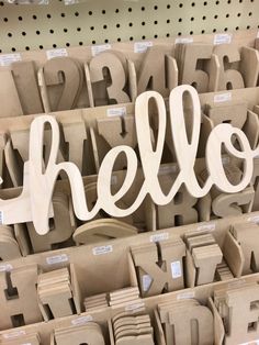 there is a sign that says hello in front of some cardboard letters and numbers on the shelf